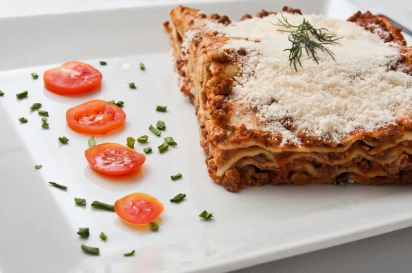 Lasagna with cherry tomatoes presentation in a plate