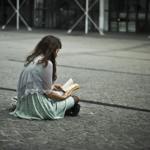 PARIS - France -  7 august 2012 -  woman sitting with book in Beaubourg place