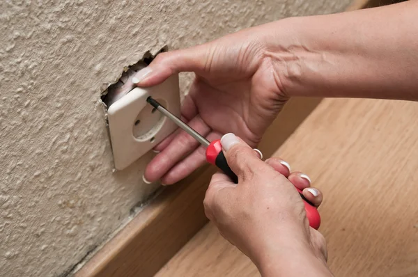 Woman changing a electrical outlet