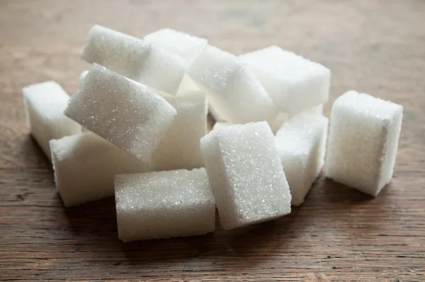 Closeup of sugar cubes on wooden background