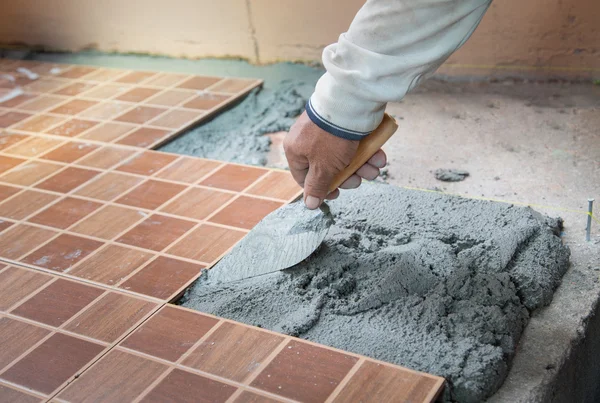 Floor tiling by manual worker