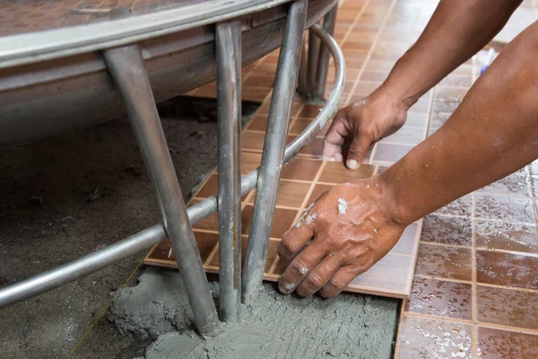 Floor tiling by manual worker