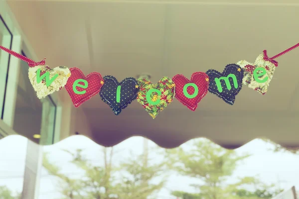 Welcome message heart alphabet hanging on mirror