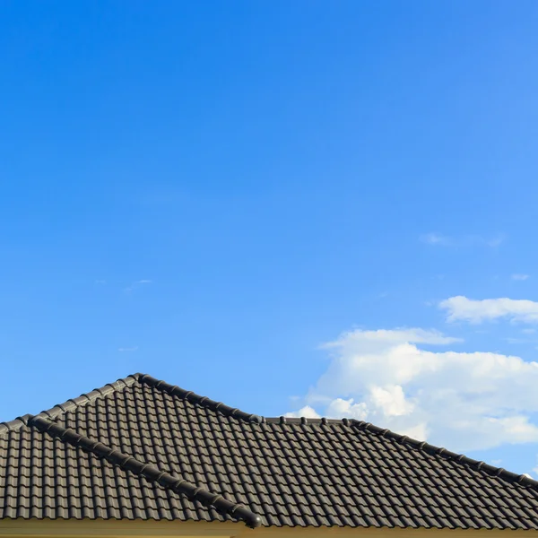Black tile roof on a new house with clear blue sky background
