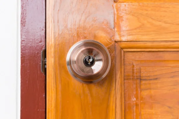 Door knob and keyhole on wooden door