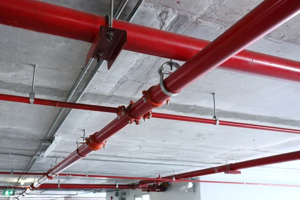 Red pipeline extinguishing water in industrial building