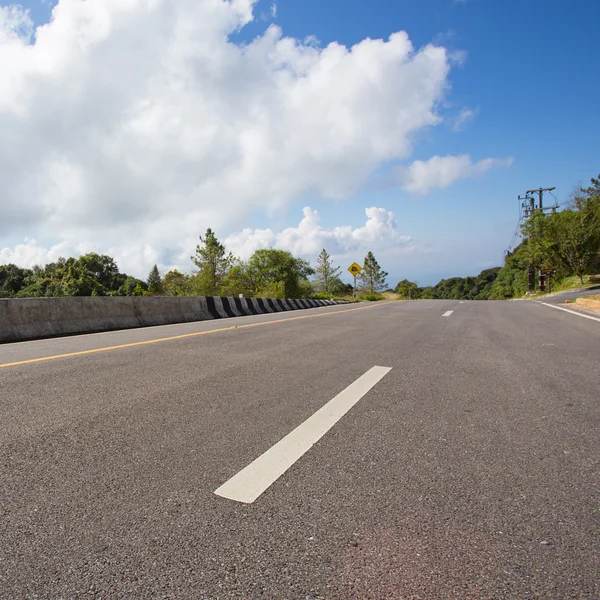 Asphalt roadway with cloud blue sky background