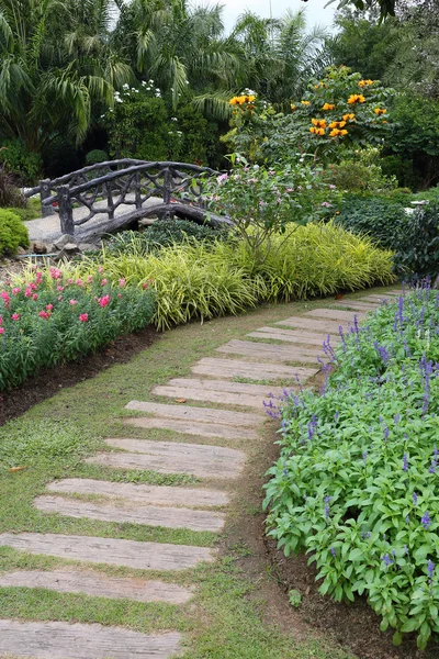 Landscape of floral gardening with pathway and bridge in garden