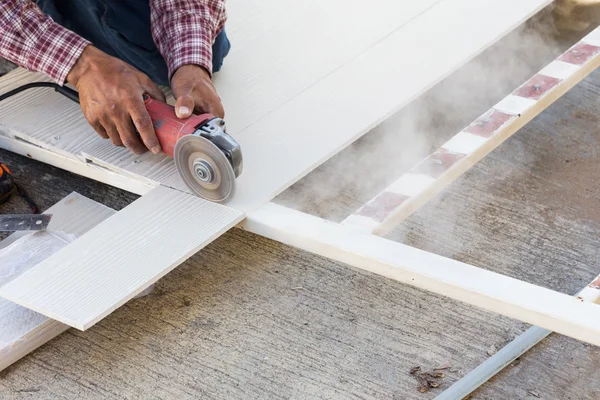 Carpenter hands using electric saw on wood at construction site