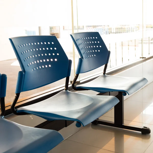 Customer waiting area with rows of blue seats in office