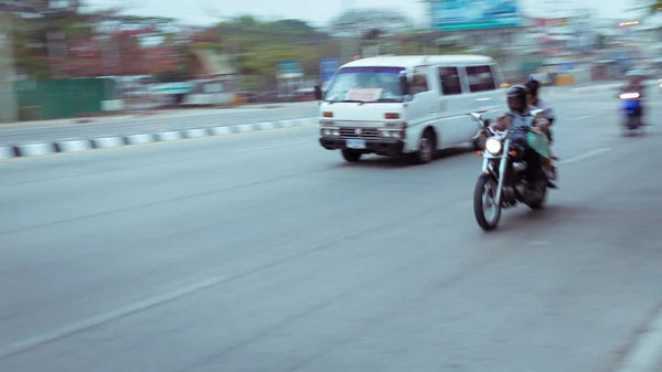 Car and motorcycle driving on road with traffic jam in the city