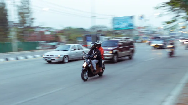 Car and motorcycle driving on road with traffic jam in the city