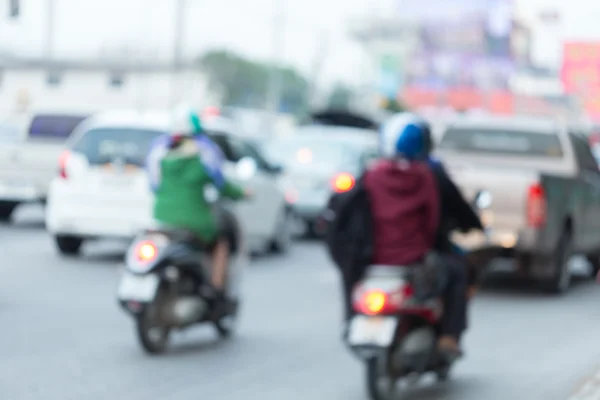 Car and motorcycle driving on road with traffic jam in the city