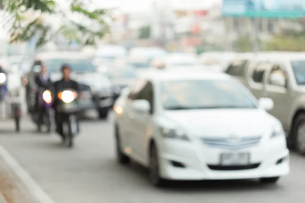 Car and motorcycle driving on road with traffic jam in the city