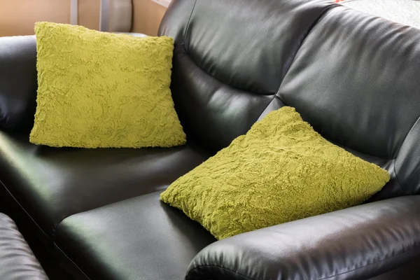 Black leather sofa furniture with green pillow in livingroom