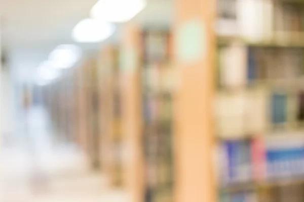 Books on bookshelf in library, abstract blur defocused