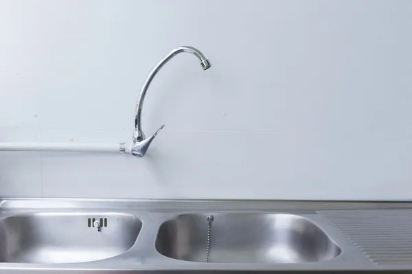 Stainless steel sink and faucet in white kitchen room