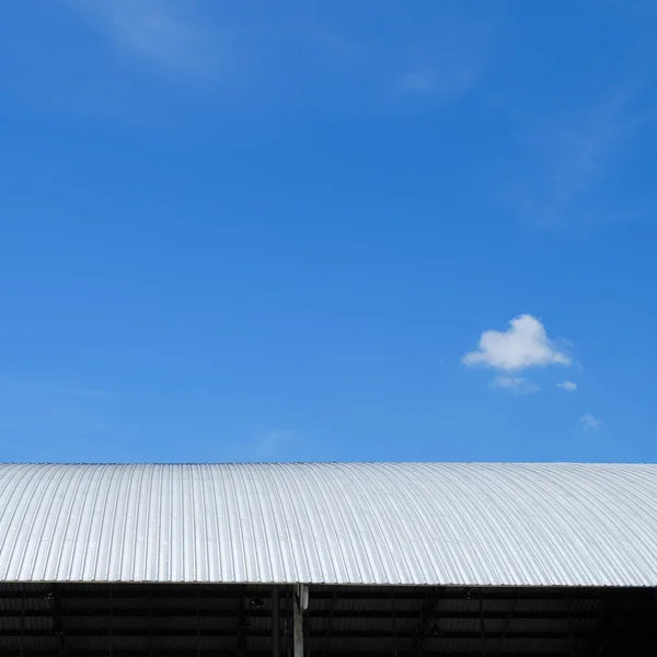 Roof of metal sheet building with clear blue sky background