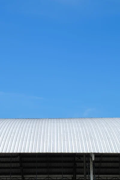 Roof of metal sheet building with clear blue sky background