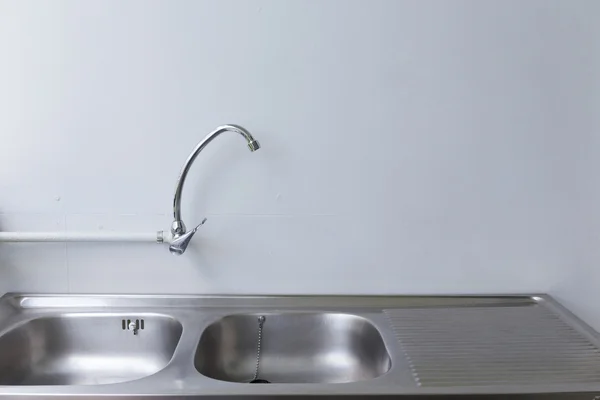 Stainless steel sink and faucet in white kitchen room