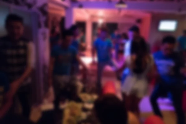 Group of young people having joyful dancing in nightclub party