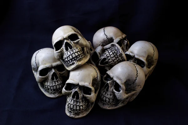 Still life photography concept with human skull on dark blue fab