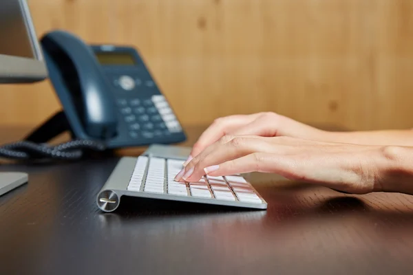 Woman typing on a computer keyboard