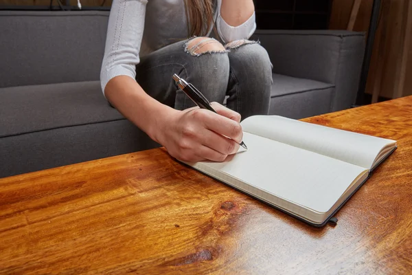 Woman writing in a book with pen