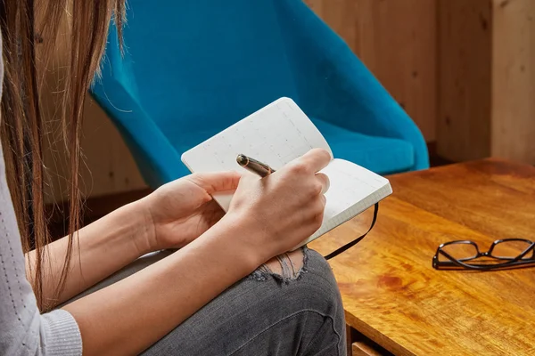 Woman writing in a book with pen