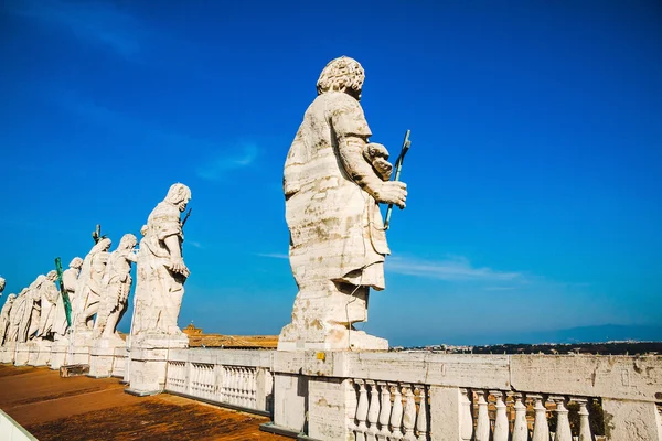 Back view of eleven statues of the saints apostles on the top of St Peter Basilica roof. Vatican