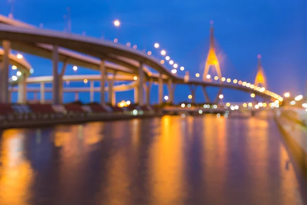 Twilight, blurred bokeh lights highway and suspension bridge