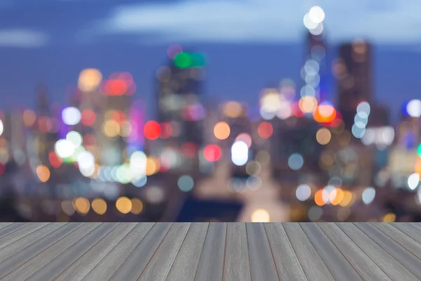 Wooden platform with abstract blurred bokeh city lights skyline