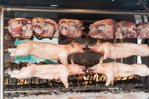 Carcasses of pork and other meat prepared on skewer.