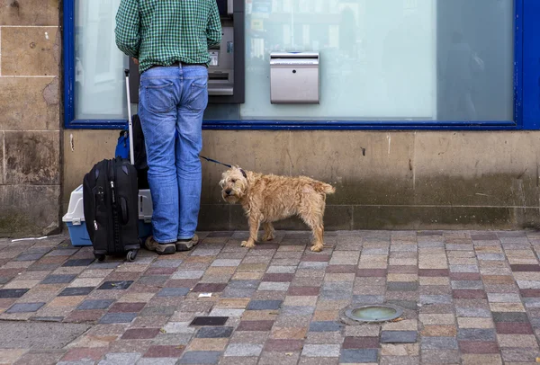 A man with his dog in front of a bank counter