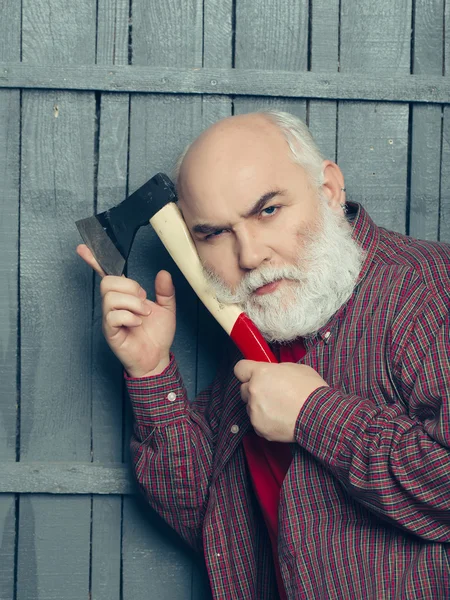 Old man shaving with axe