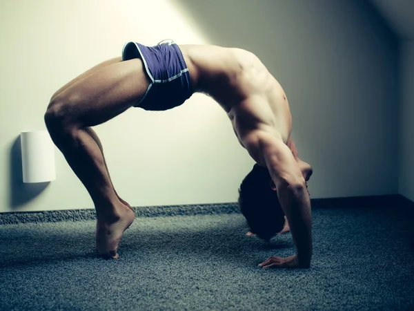 Muscular yoga man in bridge position