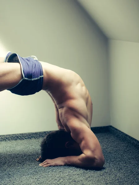 Muscular yoga man in bridge position