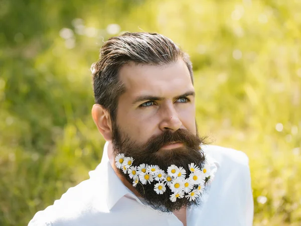 Handsome man with flowers in beard