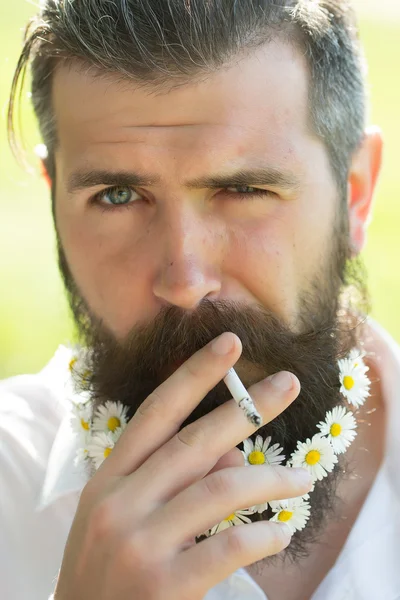 Handsome man with flowers in beard