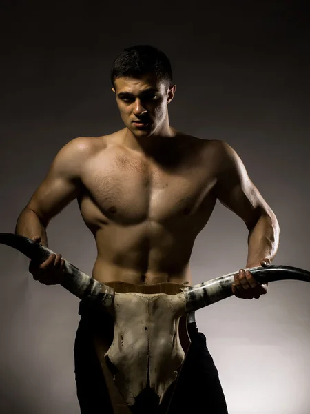 Sexy muscular man with animal skull