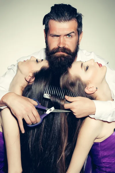 Bearded man hairdresser and two women