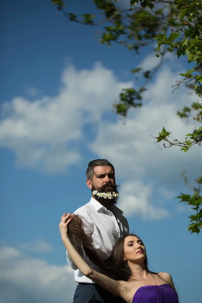 Bearded man and woman on blue sky