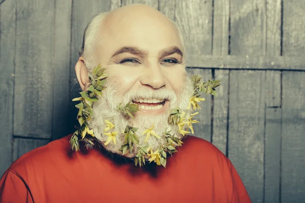 Old man with flowers and leaves in beard