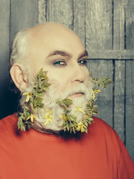 Old man with flowers and leaves in beard