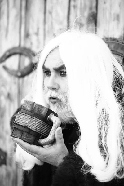 Bearded man with wooden mug