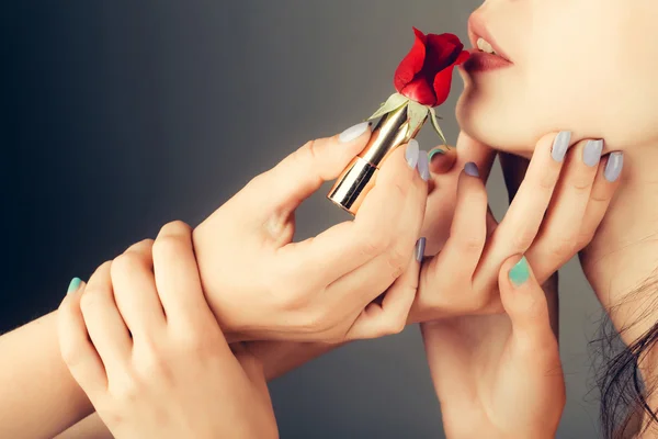 Female hands with red rose lipstick