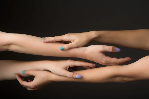 Four female hands touching