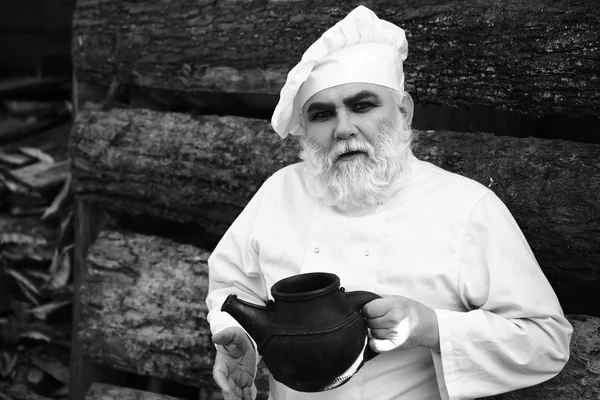 Bearded cook with iron tea kettle