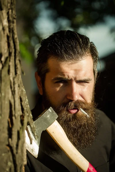 Bearded man outdoor with axe