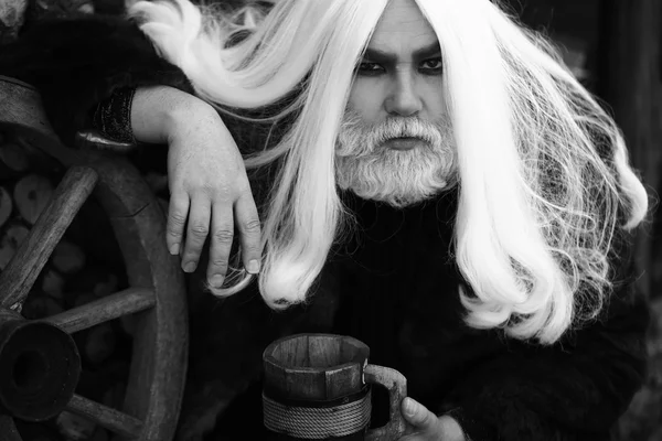 Old druid with wooden mug